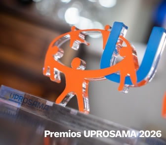 Trofeo de cristal con figuras humanas naranjas enlazadas y el texto Premios UPROSAMA 2026 sobre una base.