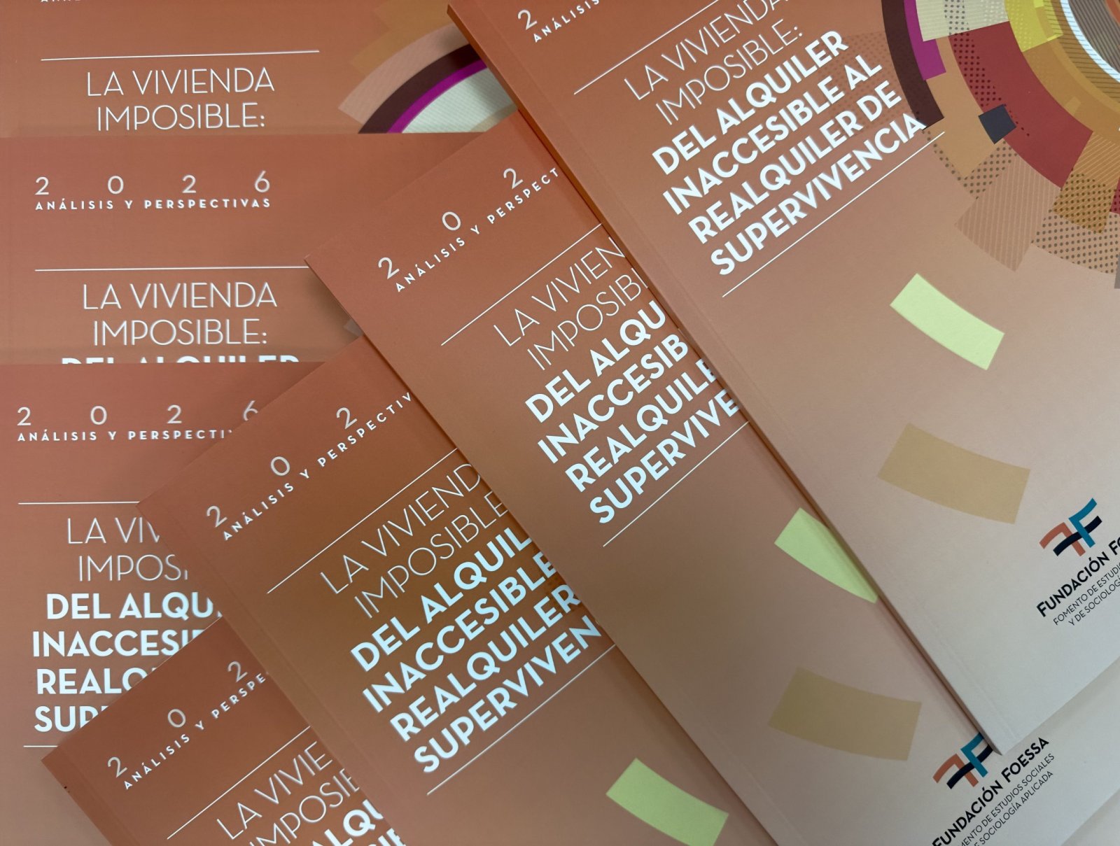 Varios ejemplares apilados de un informe de cubierta marrón titulado La vivienda imposible: del alquiler inaccesible al realquiler de supervivencia.